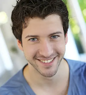 Portrait of cheerful young guy with blue eyes